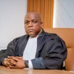 Maître David Miano en toge assis dans son fauteuil de bureau